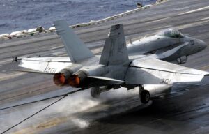 Jet on aircraft carrier being stopped by tail hook “capturing” the arresting cable