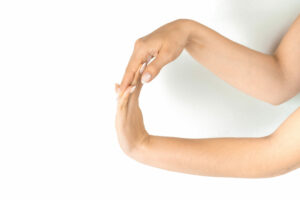 woman doing finger and wrist stretch exercise therapy on white background 
