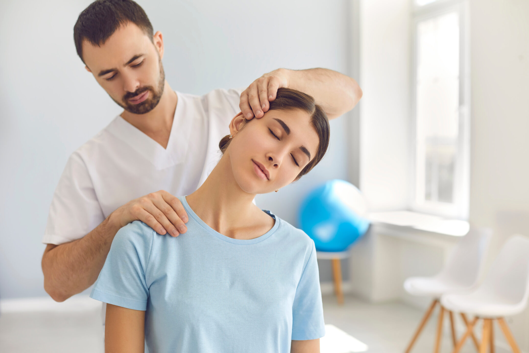 A chiropractor works on a patient’s neck.